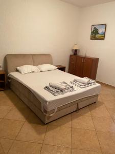 a bedroom with a bed with towels on it at Apartmani Mustur in Bijela
