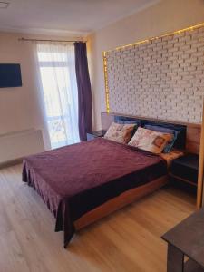 a bedroom with a large bed and a large window at Квартири подобово Івано-Франківська Nice apartments for booking in Ivano-Frankivsk