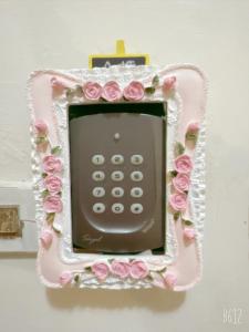 a hello kitty phone with pink roses on a wall at Warm Fengjia LesGo in Taichung
