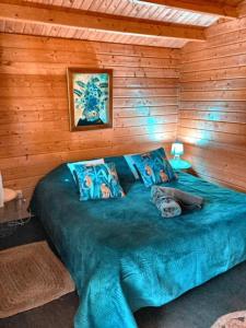 a bedroom with a blue bed in a wooden wall at La Sequana in Moisson