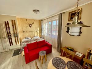 salon z czerwoną kanapą i łóżkiem w obiekcie Apartman Hubert w mieście Kašperské Hory