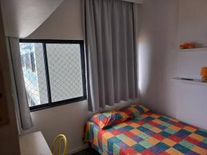 a small bedroom with a bed and a window at 2/4 Farol da Barra in Salvador