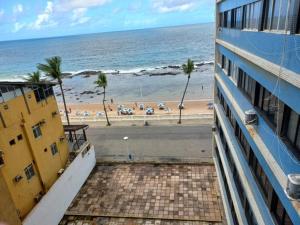 uitzicht op het strand vanaf het balkon van een gebouw bij 2/4 Farol da Barra in Salvador