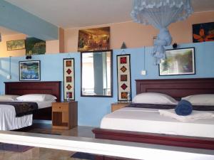 2 camas en una habitación con paredes azules en Days Inn, en Kandy