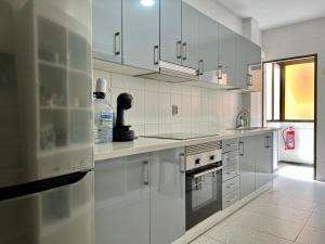 eine große weiße Küche mit weißen Schränken und Geräten in der Unterkunft Spacious 4 Bedrooms apartment for family or several friends in San Bartolomé de Tirajana