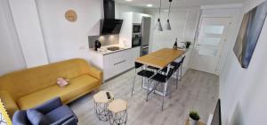 sala de estar con sofá, mesa y cocina en Villa Toston City, en Salamanca