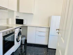 a white kitchen with a washing machine and a refrigerator at Relax in Offenbach