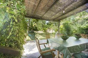 eine Terrasse mit einem Tisch und Stühlen unter einer Pergola in der Unterkunft Villa Monserrato - Goelba in Porto Azzurro