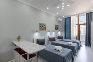 a room with three beds and a table in it at Leyla Apartments 2 in Baku