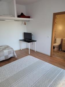 a bedroom with a laptop on a table with a bed at Silo el capricho in Madridejos