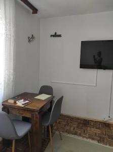 Zimmer mit einem Tisch, 2 Stühlen und einem TV in der Unterkunft Ajsha Guesthouse in Jajce