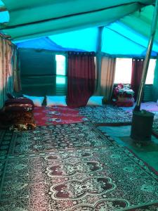 - une chambre avec un lit et un tapis dans une tente dans l'établissement City Escape Camps and Cafe Kheerganga, à Kheerganga