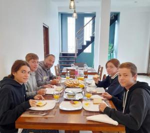 a group of people sitting at a table eating food at Pensive Villa in Nuwara Eliya