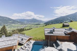 ein Haus mit Pool auf einem Hügel in der Unterkunft Chaletdorf Zaglgut Kaprun in Kaprun