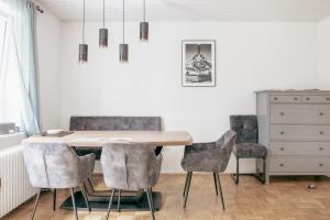 a dining room table with four chairs and a dresser at Stilvolle 2 Schlafzimmer Apartments Heidegarten, Osterheide, Zentrum in Schneverdingen