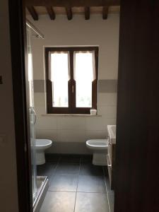 baño con 2 aseos y ventana en Casa Ornella, en Nocera Umbra