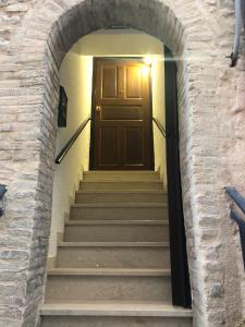 una escalera con una puerta marrón en una pared de ladrillo en Casa Ornella, en Nocera Umbra