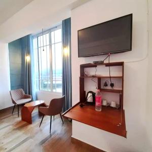 a living room with a flat screen tv on a wall at Pensive Villa in Nuwara Eliya