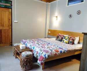 um quarto com uma cama e uma mesa em The Little Paradise em Kalimpong
