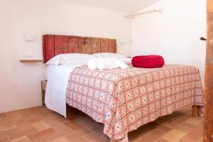 a bedroom with a bed with a red blanket at Dilà Assisi Rooms in Assisi