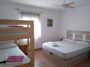 a bedroom with two bunk beds and a ceiling fan at La Caballera 17 in Santa María de Trassierra