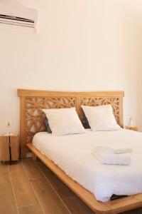 a bedroom with a wooden bed with white sheets at Le mas Louga in Flayosc