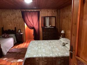 Schlafzimmer mit einem Bett, einer Kommode und einem Spiegel in der Unterkunft B&B Maison Vallomy in Lillianes