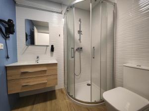 a bathroom with a shower and a toilet and a sink at Hotel Apartamentos Pueblo Mar in Calpe