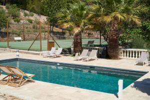 a swimming pool with lounge chairs and a tennis court at Le mas Louga in Flayosc