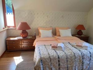 1 dormitorio con 1 cama con 2 lámparas y toallas en Villa Dona, en Kranjska Gora