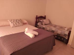 a bedroom with two beds with towels on them at Casa Quinta en Luján - Olivera in Olivera