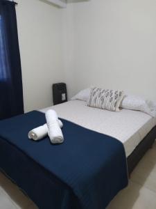 a bed with two white towels on top of it at Casa Quinta en Luján - Olivera in Olivera