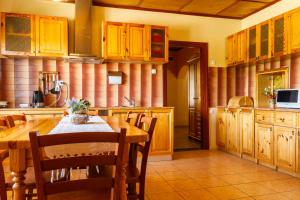 uma cozinha com armários de madeira e uma mesa e cadeiras em Viesu nams Sidrabi em Druva