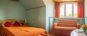 um quarto com uma cama, uma cadeira e uma janela em Viesu nams Sidrabi em Druva