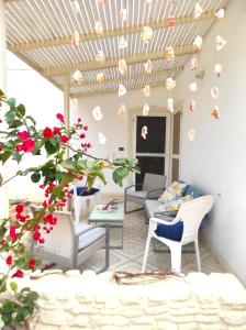 eine Terrasse mit Stühlen, einem Tisch und Blumen in der Unterkunft Beach house Agua Viva, Praia de Chaves, Boa Vista, Sal Rei, Cape Vert, 50mt spiaggia in Cabeçadas