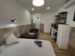 a room with a bed and a couch and a kitchen at Hotel Apartamentos Pueblo Mar in Calpe