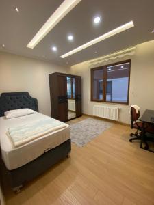 een slaapkamer met een bed, een bureau en een raam bij Sumela in Trabzon