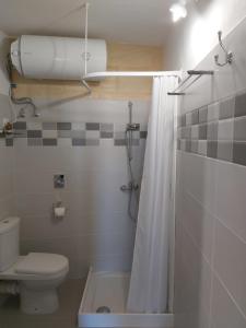 a bathroom with a toilet and a shower curtain at The Hidden Gem Boutique Hotel in Rabat