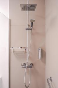 a shower with a shower head in a bathroom at Rooms & Suites Princesa Mercedes in Puerto del Carmen