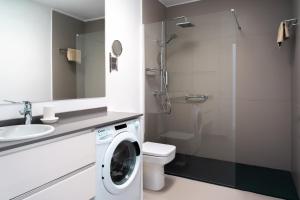 a bathroom with a toilet and a washing machine at Rooms & Suites Princesa Mercedes in Puerto del Carmen