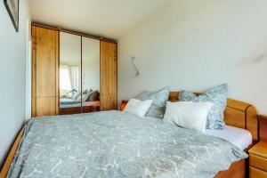 a bedroom with a large bed with blue and white pillows at Ferienwohnung Harz-Panorama 434 in Hohegeiß