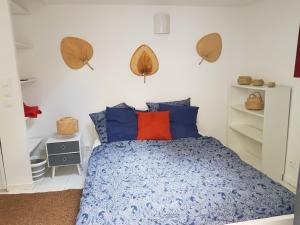 a bedroom with a bed with blue and orange pillows at Studio chez Thomas in Paris