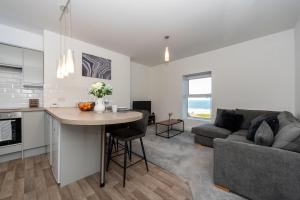 cocina y sala de estar con mesa y sofá en Sea Views Modern Two Bedroom Apartment en Lowestoft