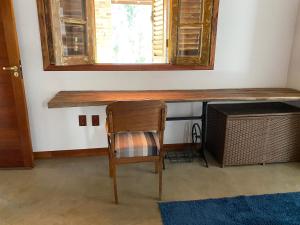a chair and a desk in a room with a window at Flores de Cunha in Cunha