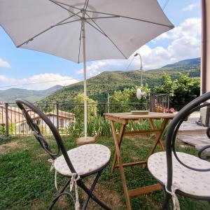 een tafel en twee stoelen met een paraplu bij La casetta di Mizar in Lizzano in Belvedere
