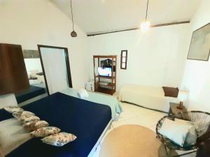 Sala de estar con 2 camas y espejo en Arraial Casinha Centro, en Arraial d'Ajuda