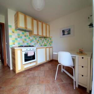 a kitchen with a stove and a white chair in it at La casetta di Mizar in Lizzano in Belvedere