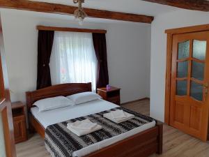 een slaapkamer met een bed, een raam en een deur bij Wild-Traditional Bucovina in Câmpulung Moldovenesc