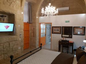 ラバトにあるThe Hidden Gem Boutique Hotelのベッドと壁掛けテレビのある寝室