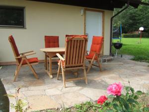4 sillas y una mesa en el patio en Ferienwohnung Schwahn, en Kleinschönach